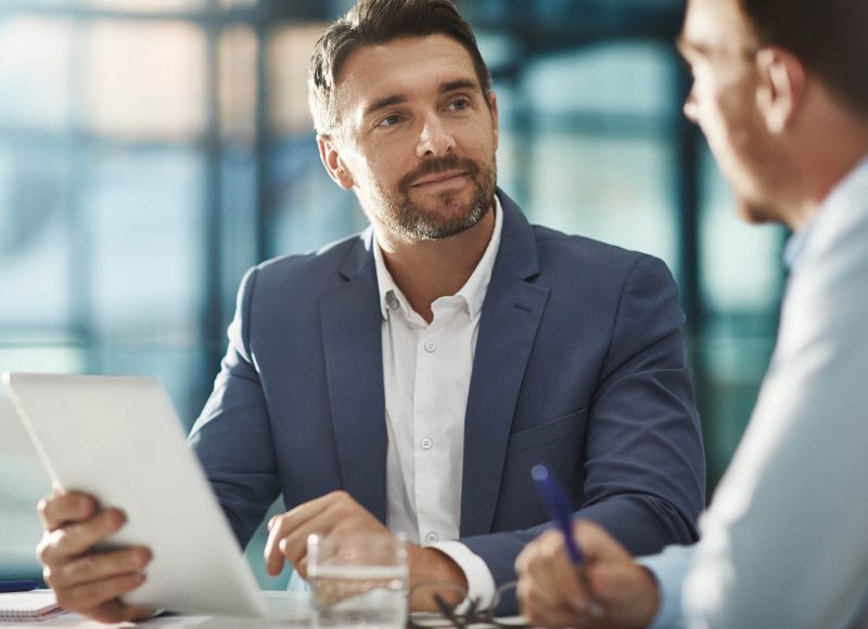 Tablet, teamwork and business people in meeting in office workplace. Collaboration, digital technology and men or workers with touchscreen planning sales, analysis or strategy in company