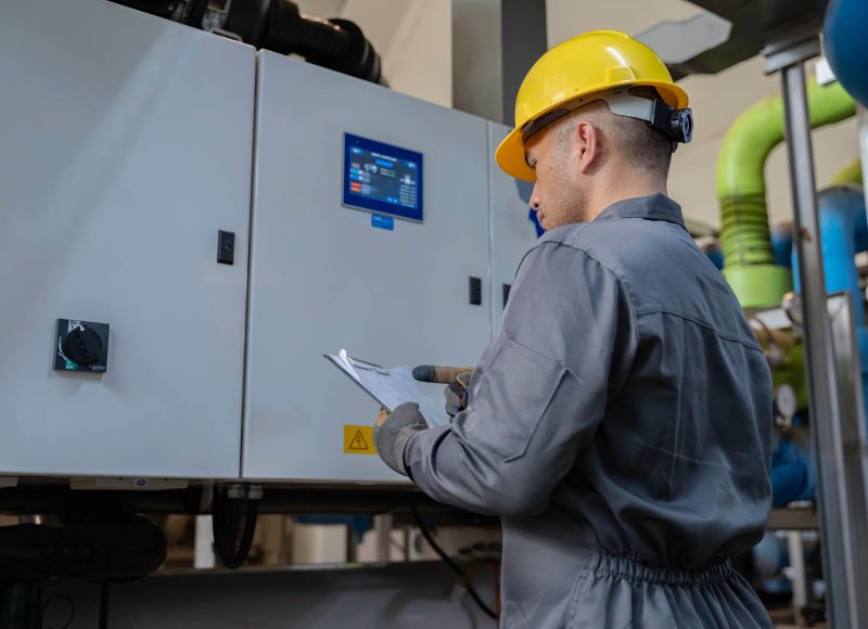 Professional technician inspecting electrical control panel in a